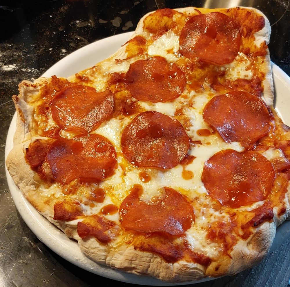 Selbstgemachte Pizza mit Mozzarella und Fake-Salami, frisch aus dem Ofen