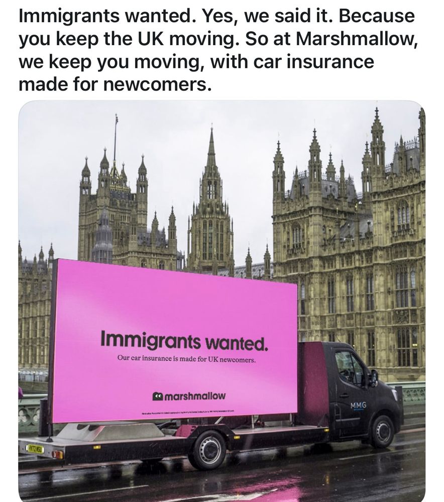 Social media advertisement for Marshmallow insurance company with a truck in front of UK parliament with big hot pink sign reading “immigrants wanted. Our car insurance is made for UK newcomers.” Text in post reads “immigrants wanted. Yes, we said it. Because you keep the UK moving. So at Marshmallow, we keep going moving, with car insurance made for newcomers”. 