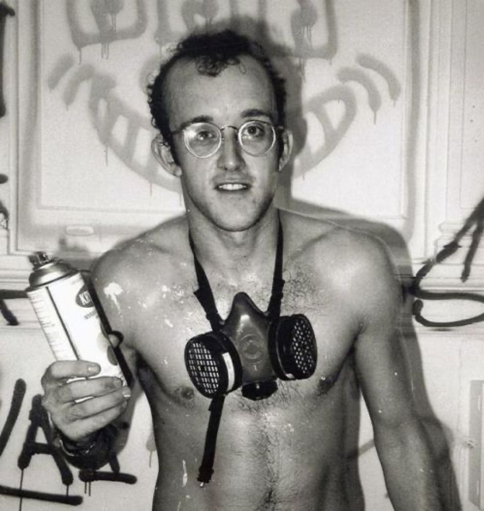 Keith Harring poses in a resperator holding a can of spray paint