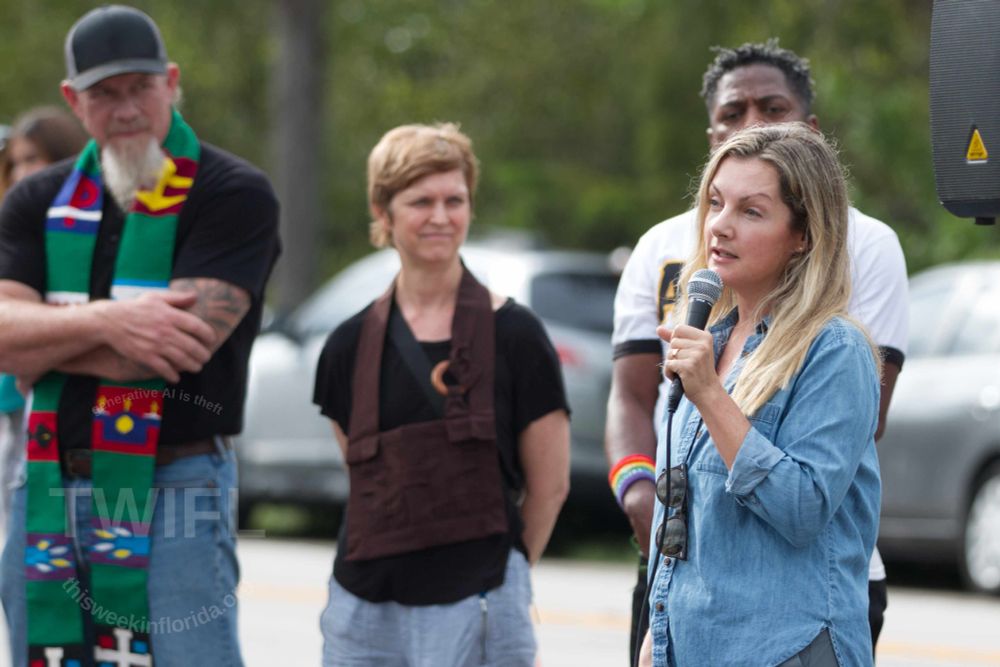 Eve Samples of Friends of the Everglades tells the audience about how the lawsuit to close the abomination is going while clergy listen in the background during the prayer vigil across the street from the South Florida Detention Center. 