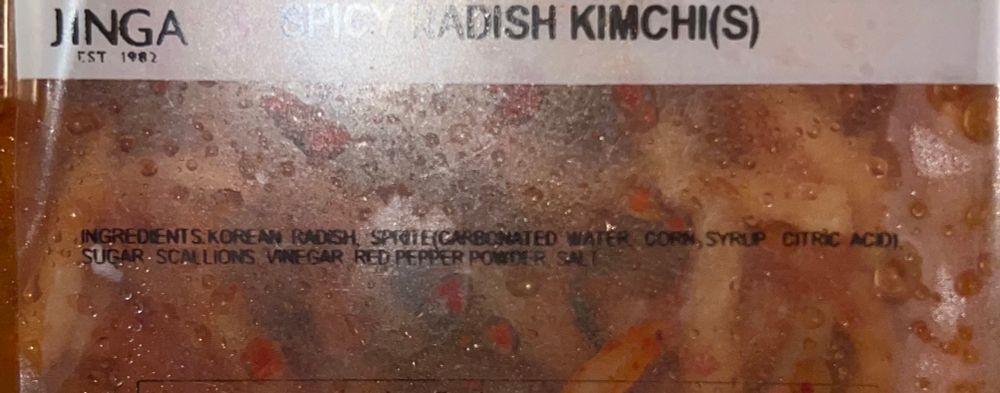 Picture of radish container that's says "spicy radish kimchi(s)" and then "ingredients: korean radish, sprite (carbonated water, corn syrup, citric acid), sugar, scallions, vinegar, red pepper powder, salt"
