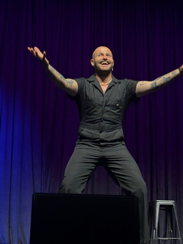 Jacob Andrew Sharpe standing on stage at the Riverside Theatre 