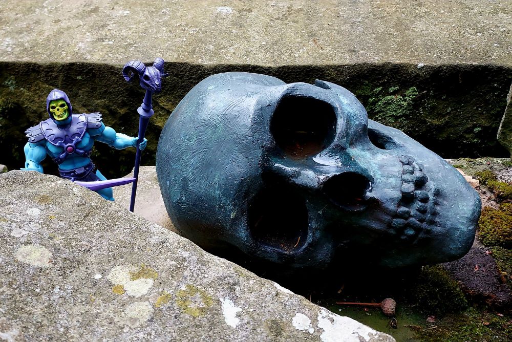 Skeletor poses with a bronze skull