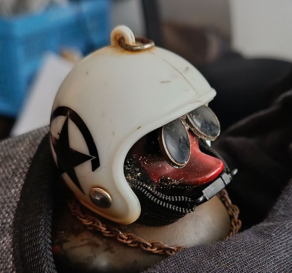 Closer up van een zwart badeendje met een helm en zonnebril op