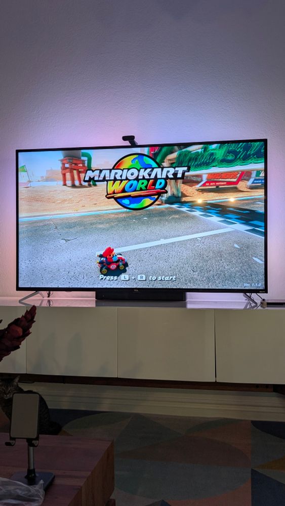 Tv showing the Mario Kart World intro scene with Mario driving.