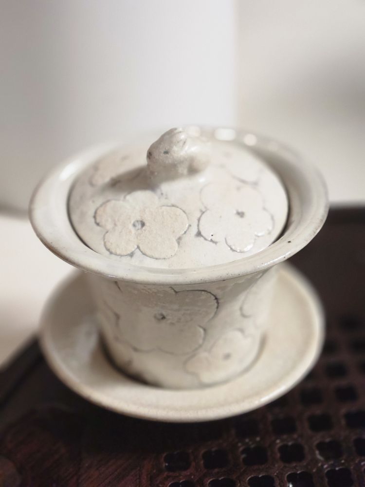 공림요에서 만들어진 토끼 개완의 사진. 우윳빛 분청 소재, 꽃잎 다섯 개짜리 꽃을 단순화시킨 모양의 패턴이 새겨져있으며 뚜껑 손잡이는 작은 토끼모양임.