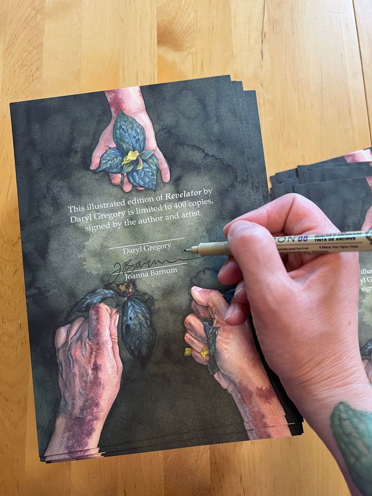 Photo of the artist’s hand with a pen signing a stack of illustrated signature pages for a book. The illustration shows the hands of three different people holding trillium flowers. The text reads “This illustrated edition of Revelator by Daryl Gregory is limited to 400 copies signed by the author and artist.” 
