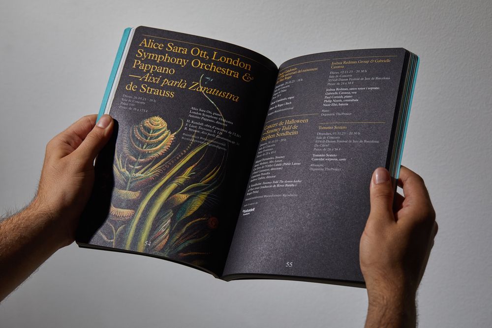 A photo of the printed seasonal program of Palau de la Música Catalana with art by entangled Others.