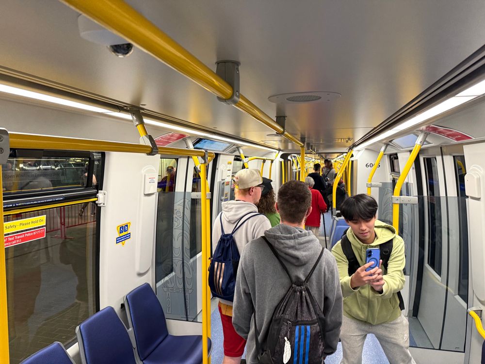 Looking down the inside of the new Mark 5 train, with people checking looking through it.