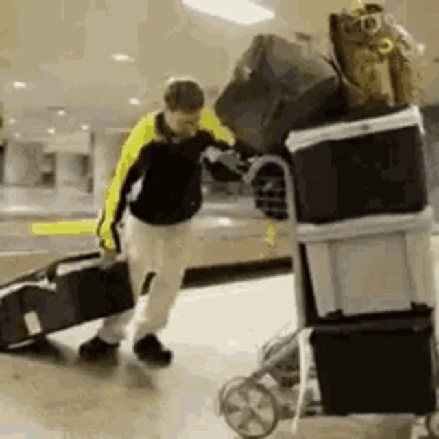 a man is pushing a cart filled with luggage and boxes .