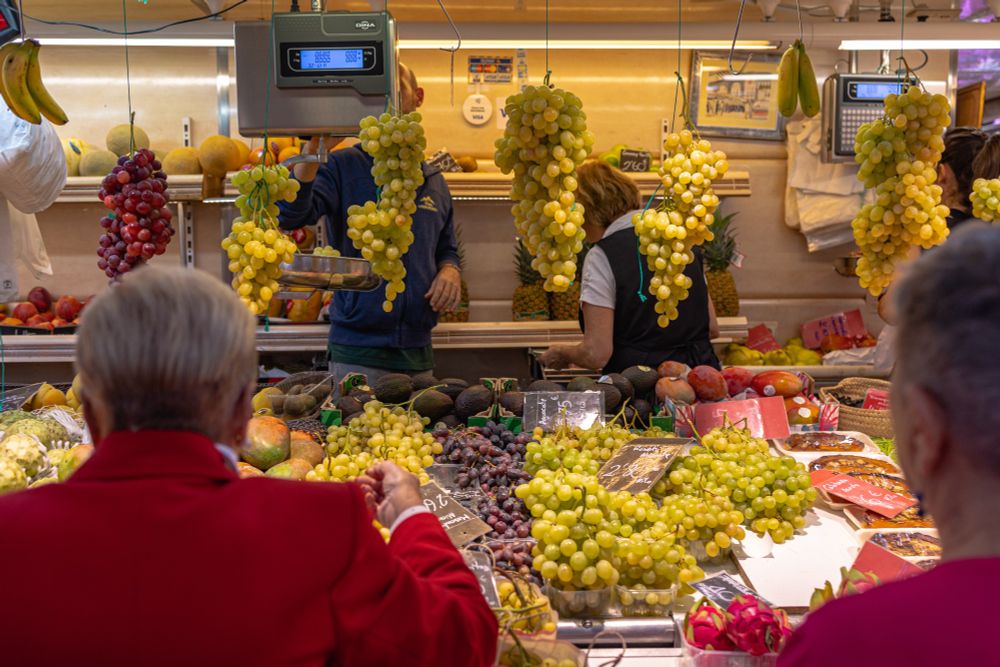2022-10-28 Valencia Spain - Color photo in the Central Market of Valencia an elderly couple is buying grapes from a produce vender that is displaying a large number of green and red grapes.

Canon R6 35mm f3.2 1/320 iso320