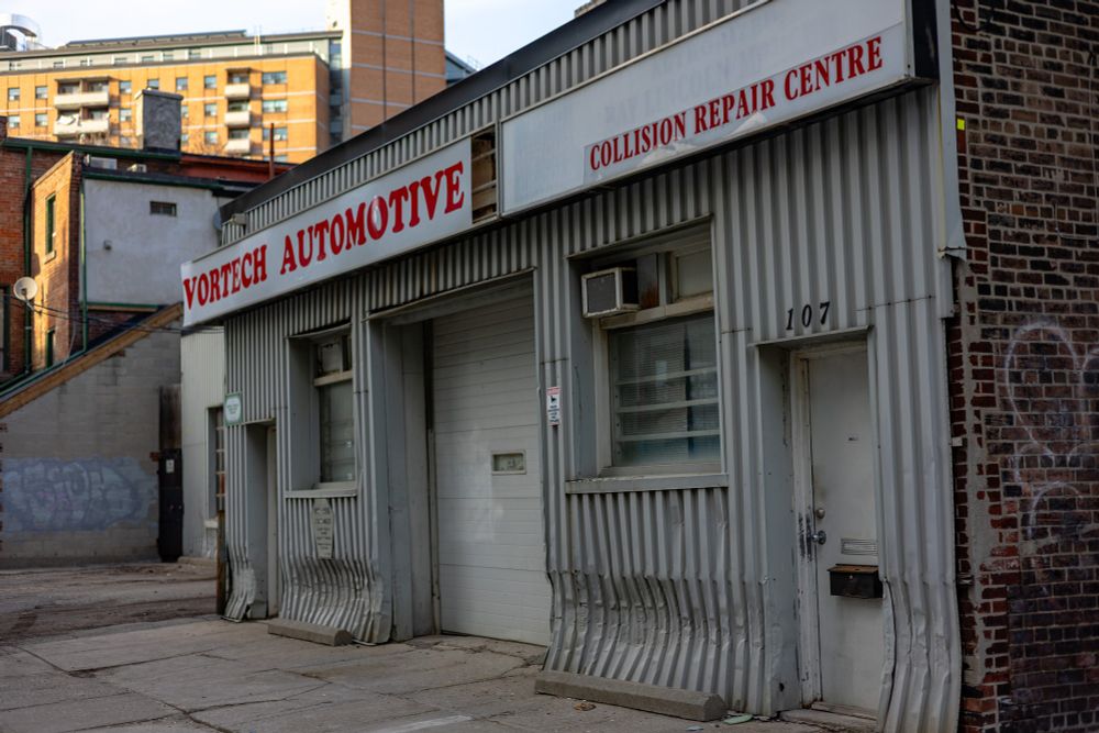 2025-04-15 Toronto, Ontario, Canada - Color photo of the Vortech Automotive business front, the vertical corrugated metal facade is dented aligned bumpers of the parking spots.

Canon R6 50mm f2.8 1/500s iso160