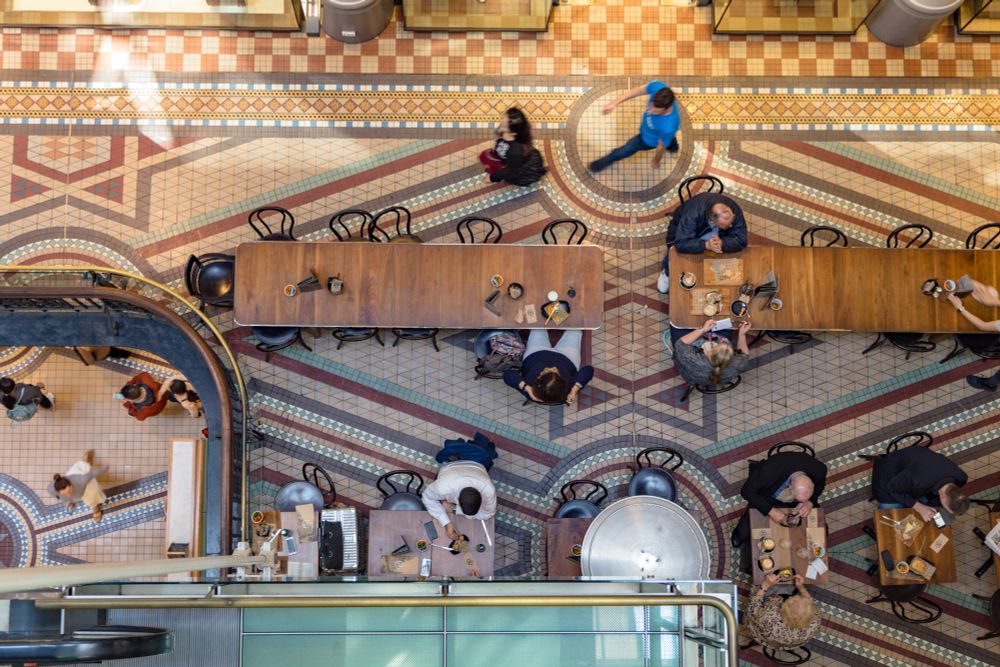 2018-09-28 Sydney Australia - Color photo looking down from the top floor of the Queen Victoria Building, now converted to a shopping arcade. Multiple floors of intricately art deco tiled floors are visible with the main floor containing a busy dining area.

Canon 6D 50mm f4.5 1/50sec iso500