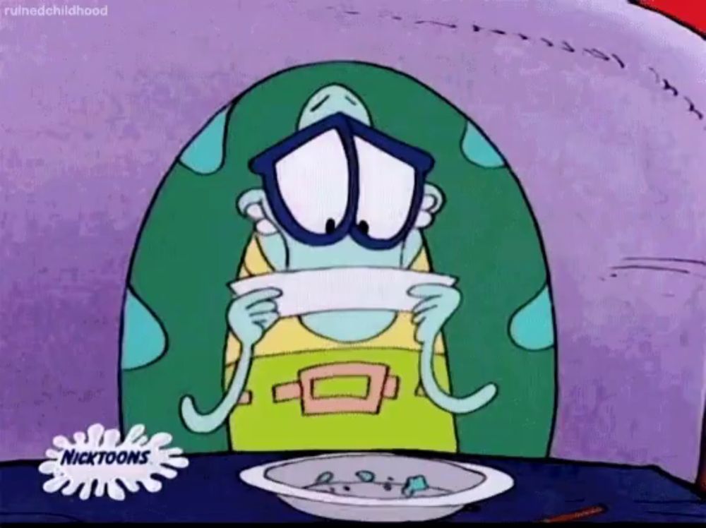 a cartoon character from nickelodeon sits at a table with a bowl of food in front of him