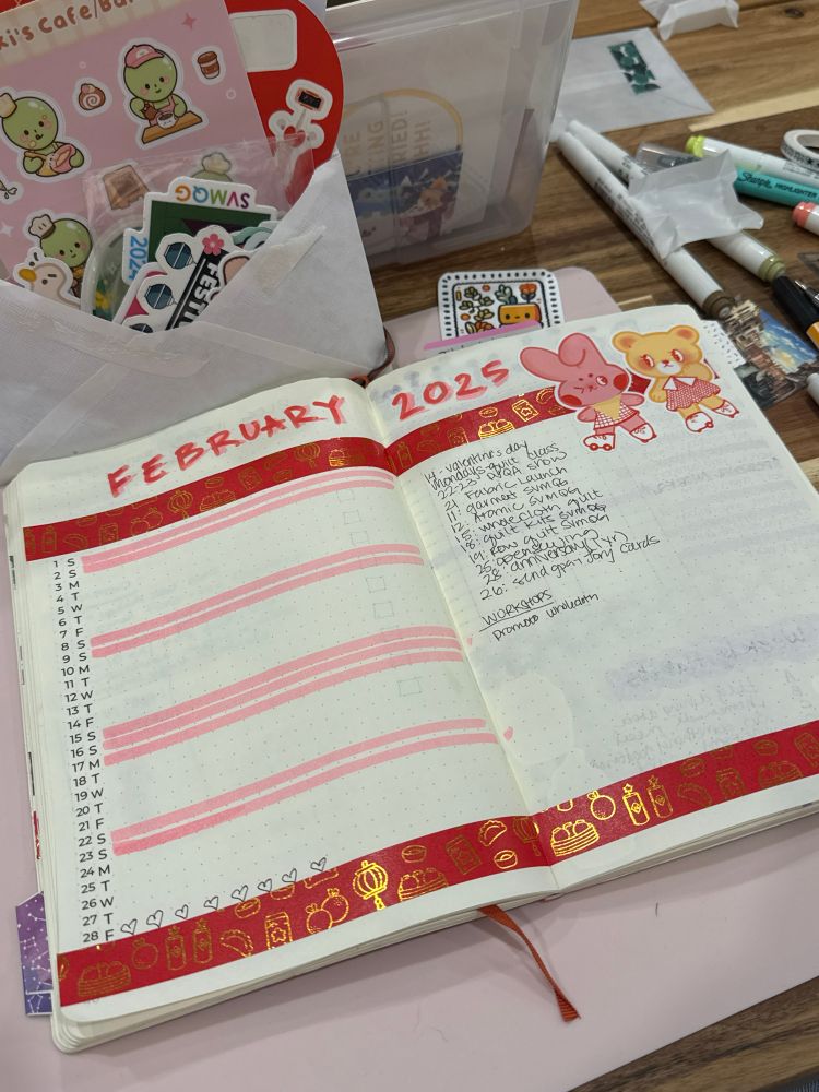 Photo of February 2025 bujo spread in a red and pink theme with lunar new year washi tape and galentines stickers