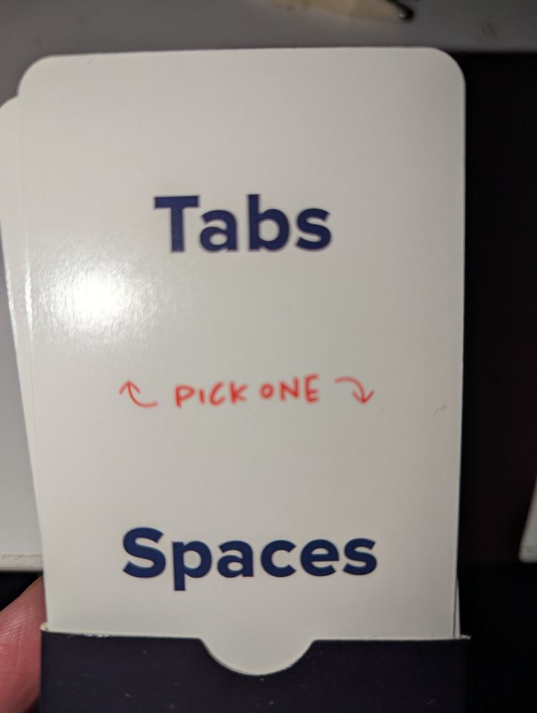 A card from the pack, two options "Tabs" and "Spaces", in the middle "pick one".