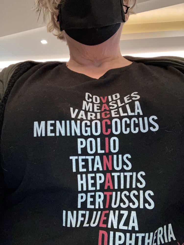 Picture of me in a t-shirt that lists various vaccinateable diseases in white text as noted below, with one letter in each highlighted in red so that red top to bottom it says VACCINATED. 

COVID
MEASLES
VARICELLA
MENINGOCOCCUS
POLIO
TETANUS
HEPATITIS
PERTUSSIS
INFLUENZA
DIPTHERIA