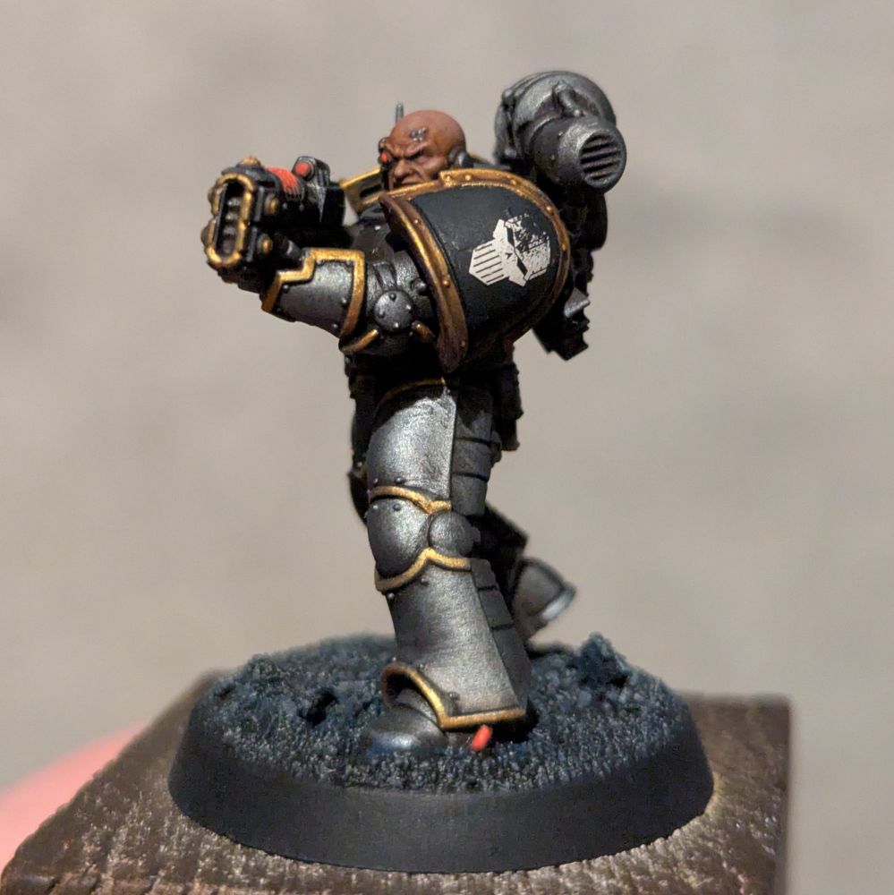 An iron warrior miniature equipped with a volkite charger