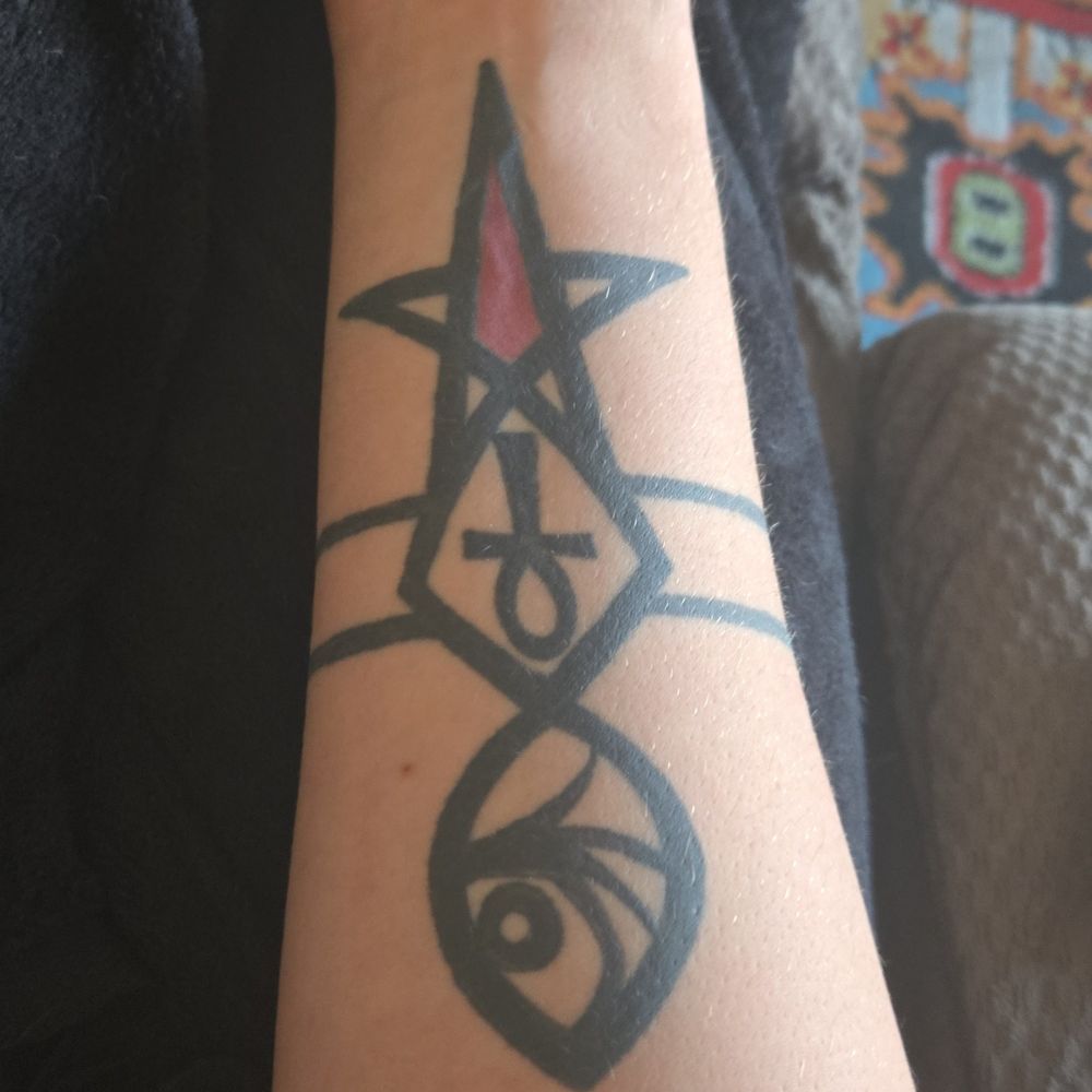 Tattoo on my right arm it is a pentagram closest to my wrist the the center being filled in red. It blends into a DNA strand that goes down the forearm. Connected to the first part of the DNA strand and bottom of the pentagram is equality bars. I have Egyptian ankh in the first DNA section and a eye for vfd from series of unfortunately events in the second ^-^