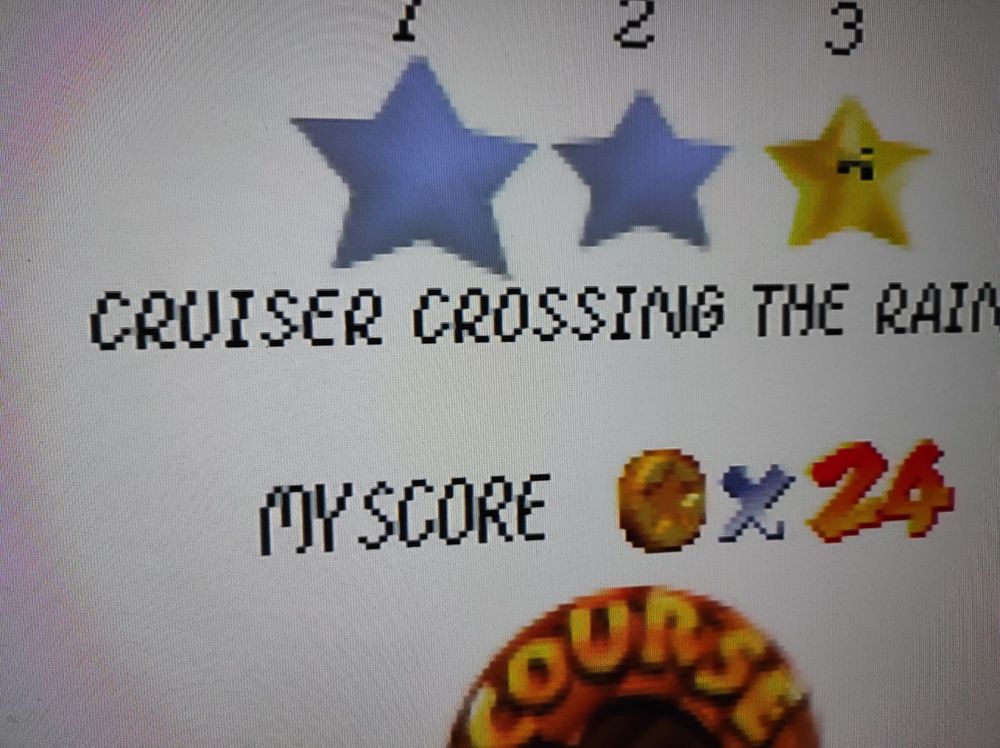 Closeup photo of Mario 64's star selection screen for Rainbow Ride, showing some ghosting/color bleed/shadows at high contrast edges in the text, ex. inside the letters M and N, and between M and Y or R and U