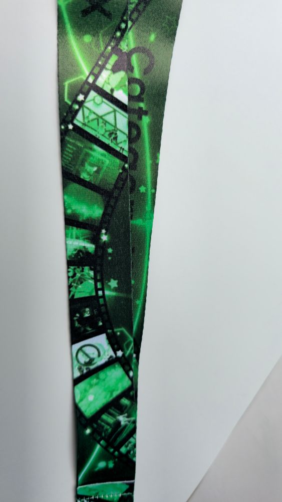 A green lanyard that says "category x" it has a film strip design with images from amvs within the strip.