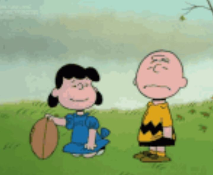 Lucy holding a football for a skeptical Charlie Brown.