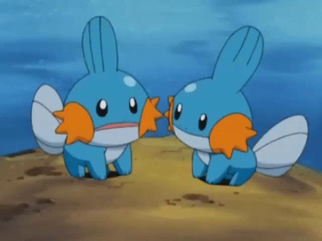 two blue and orange pokemon are sitting next to each other on a sandy beach