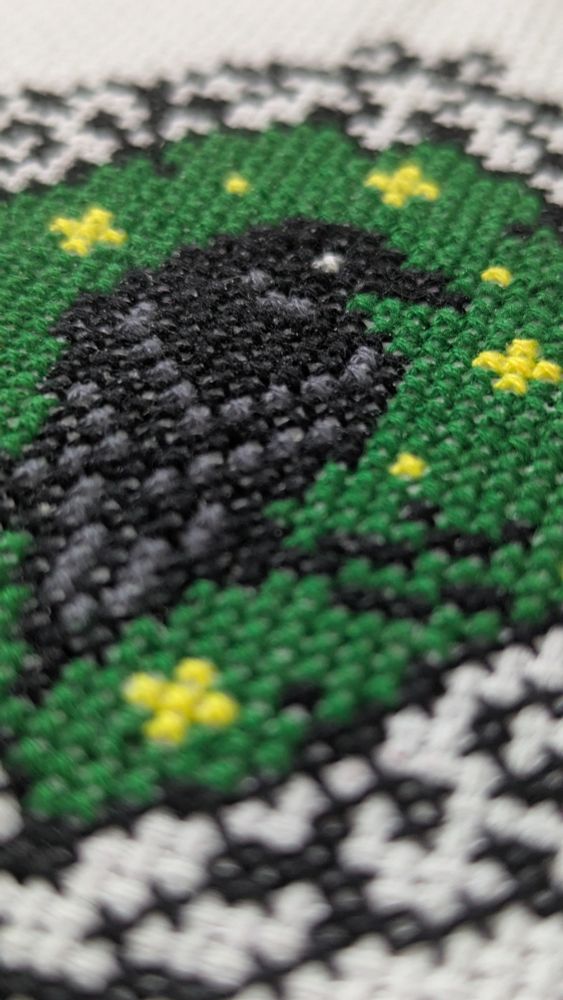 A close up of the stitches on the raven piece. 