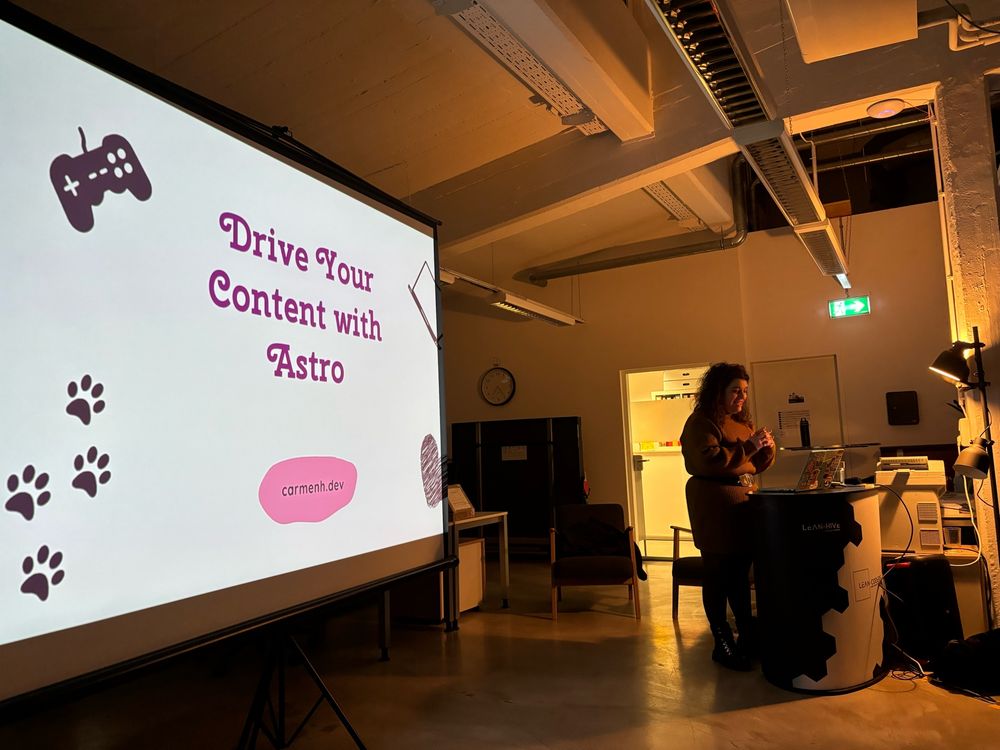 Carmen on stage, first slide with the talk title in the back