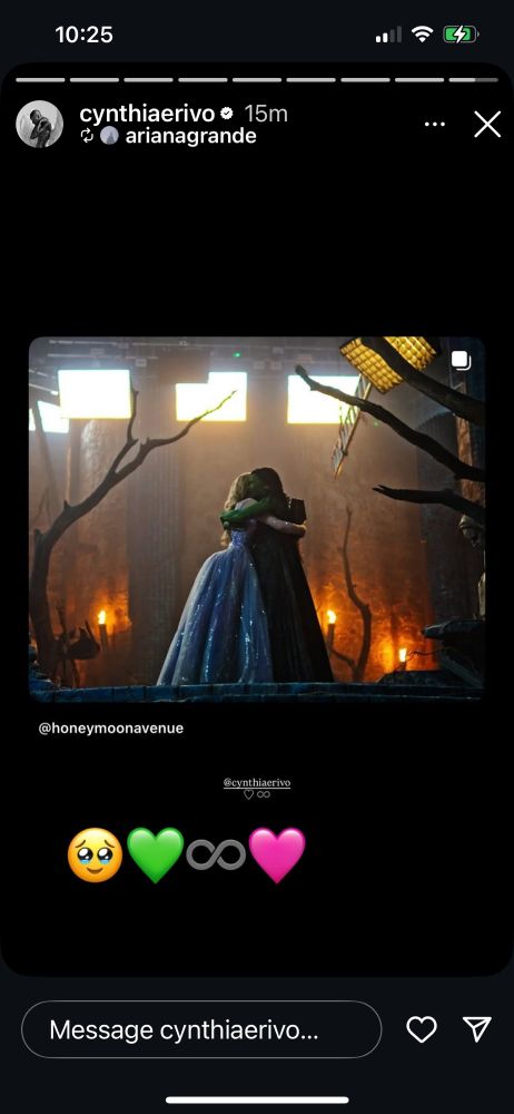 a screenshot of cynthia reposting ari’s instagram story featuring a photo from the wicked: for good set with the two of them hugging and added the emojis 🥹💚♾️🩷 