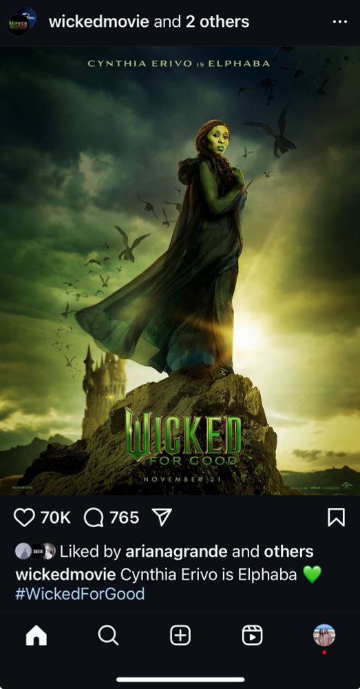 the official wicked: for good character poster for elphaba, showcasing cynthia erivo standing on top of a cliff, with a green sky and flying monkeys in the background. kiamo ko can also be seen in the distance.
