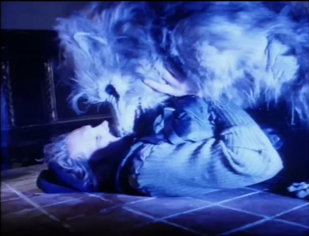 A still frame from the movie "Project: Metal Beast". A werewolf is biting the neck of a human pinned beneath them.