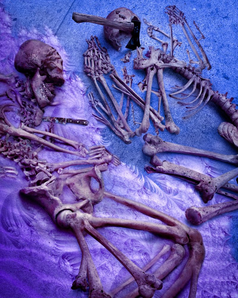 Two human skeletons face each other on the floor, each with too many limbs and bones to count. A rusted knife is embedded into one's chest, and the other's skull has been shattered by a hand axe, which is still stuck in the pavement. Sand, swirling in endless fractal patterns, is starting to cover the bodies.