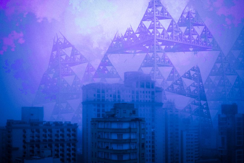 The foggy landscape of an empty city. Over the buildings looms an enormous pyramid of steel, made of smaller and smaller pyramids. It appears to be falling apart, beams falling to the abandoned city below.