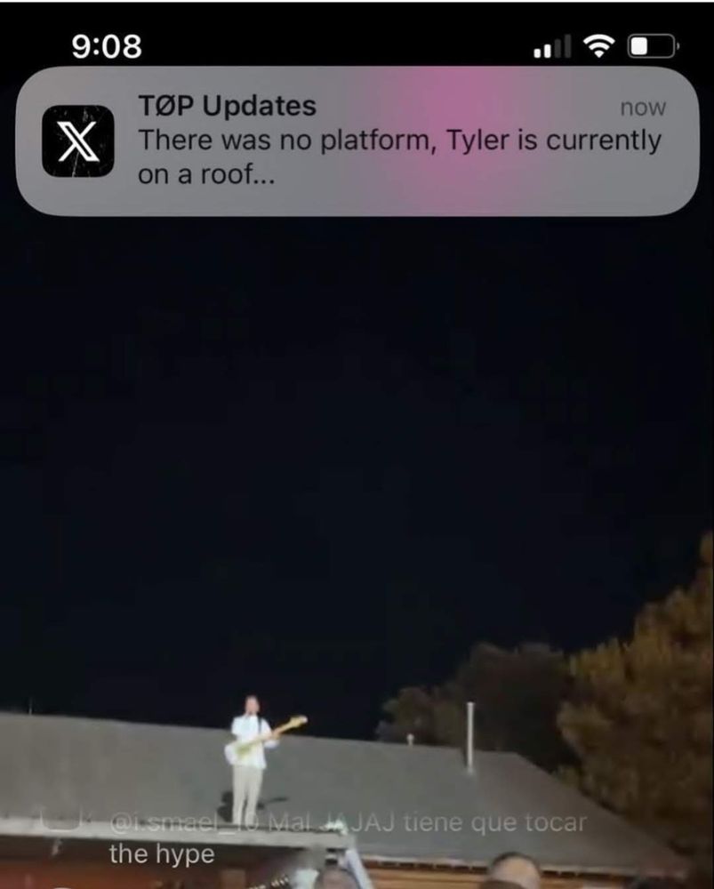 Screenshot of an Instagram livestream of a show where tyler is standing on a roof with his guitar. A notification from TØP Updates is visible saying "There was no platform, Tyler is currently on a roof..."