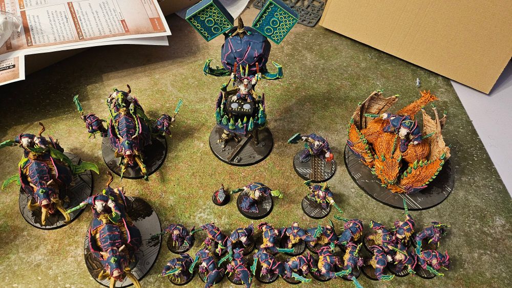 A photo of my ironjawz army with mostly blue armour trimmed with neon pink and green weaponry with neon yellow edges.
