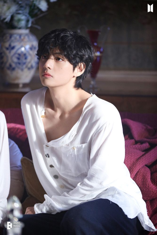 Taehyung posing in a loose white shirt