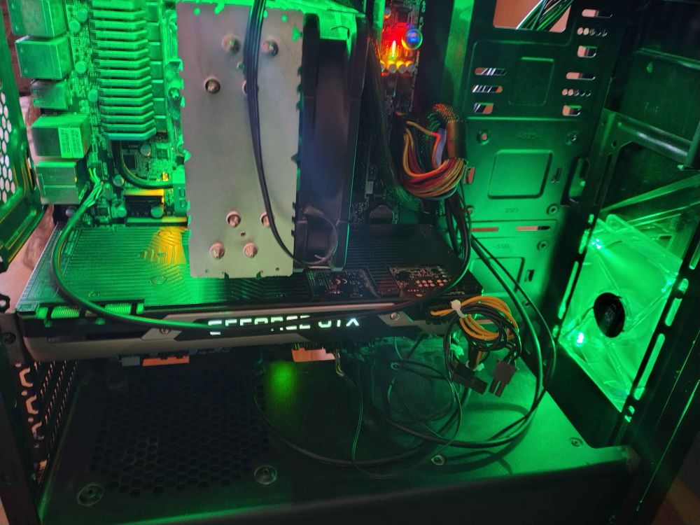 a computer from the inside. visible are a tower cooler, a founder's edition GTX 980, a Gigabyte z68x board, and two green fans.