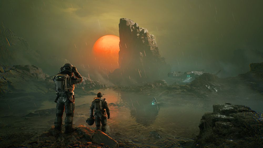 Astronauts approach a rocky landscape and a body of water on an alien location, a red moon and rocky pillar dominate the horizon. Rain pours from the sky, and fog steams up from the water's surface. We see their ship and a figure in the distance.
