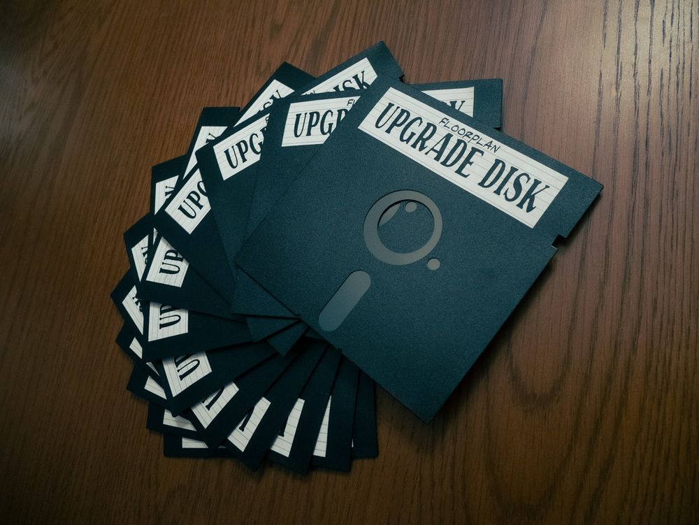 A stack of physical upgrade disks, which look like old 5.25" floppies with labels stuck on them that read "Floorplan Upgrade Disk". But nobody in their right mind would bother to put any actual data on these prop giveaways, right? 