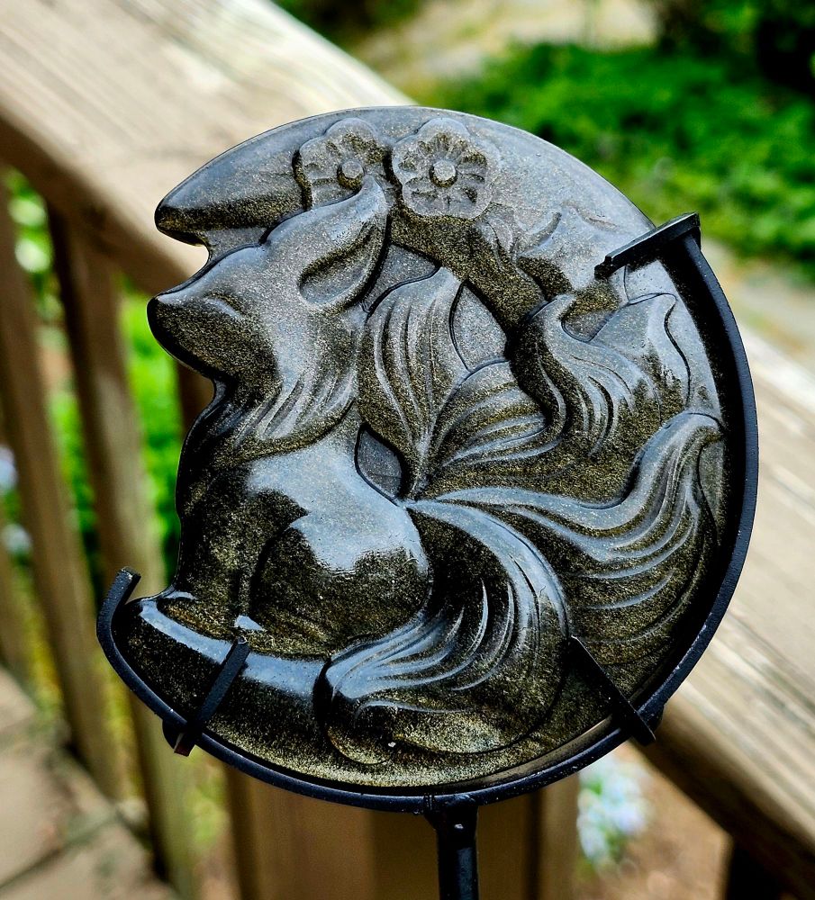 An obsidian carving of a 9 tail fox on moon with flowers 
