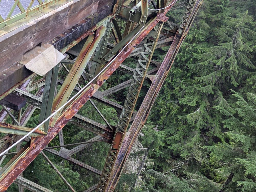 the view over the edge of a tall, old bridge spanning a significant valley over a river