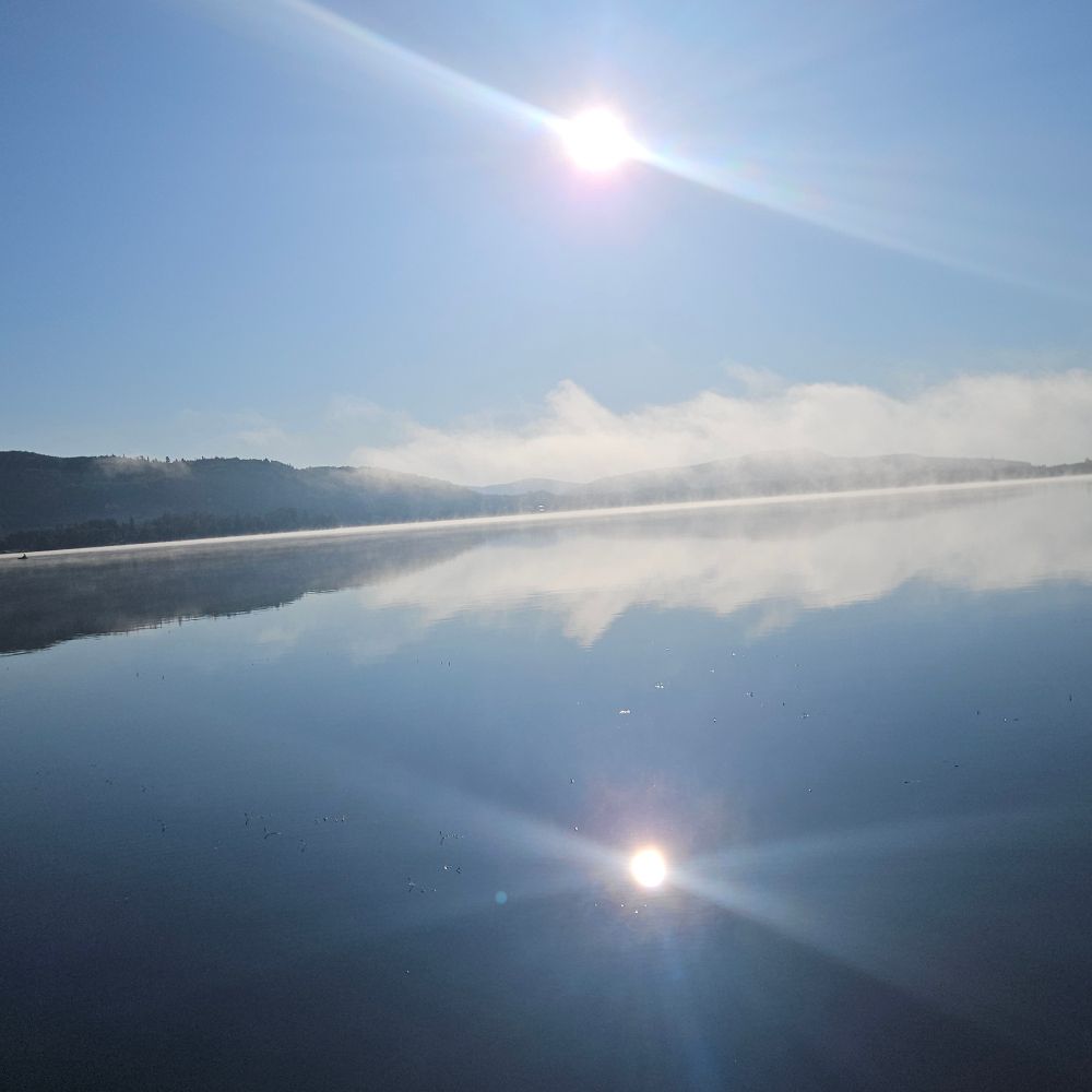 Reflets du soleil et brume sur un lac, Québec, juillet 2025