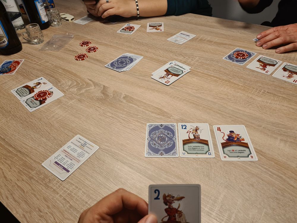 Spielmaterial des Kartenspiels Ratjack auf einem Spieltisch.