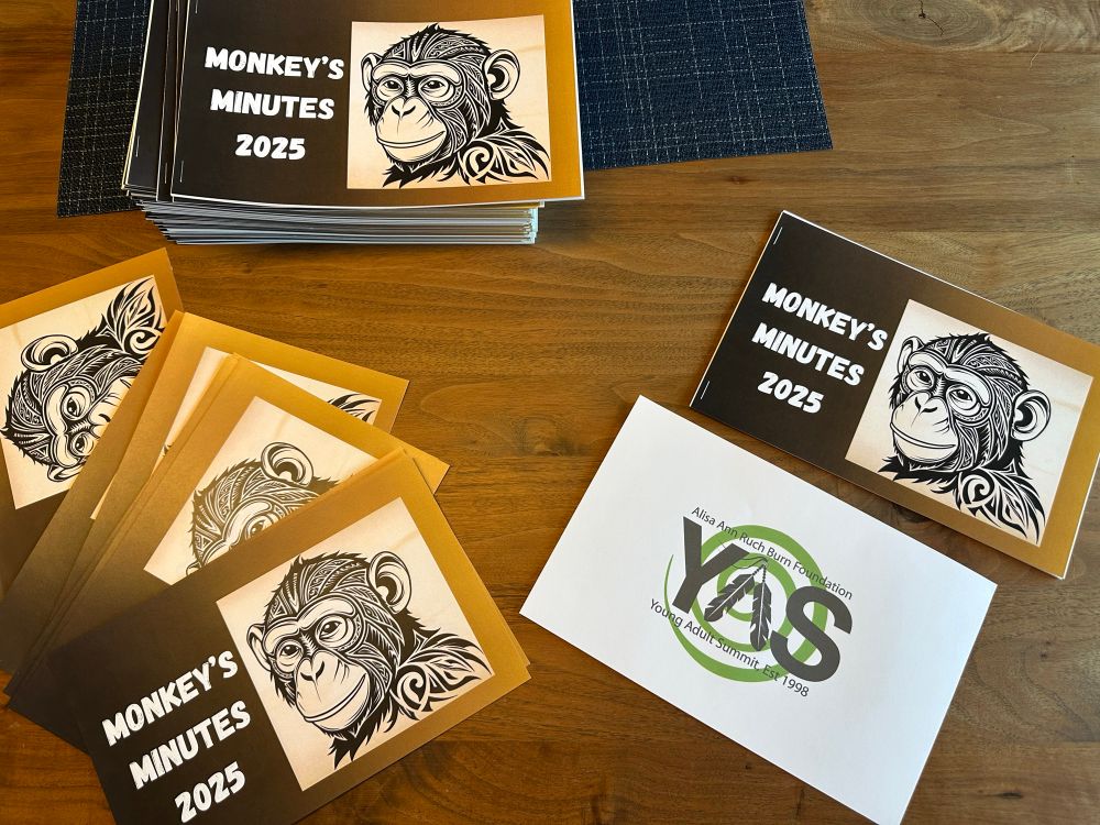 Booklets in a pile showing front and back, titled “Monkey’s Minutes 2025” with an illustration of an ape’s head and logo for Alisa Ann Ruch Burn Foundation Young Adult Summit