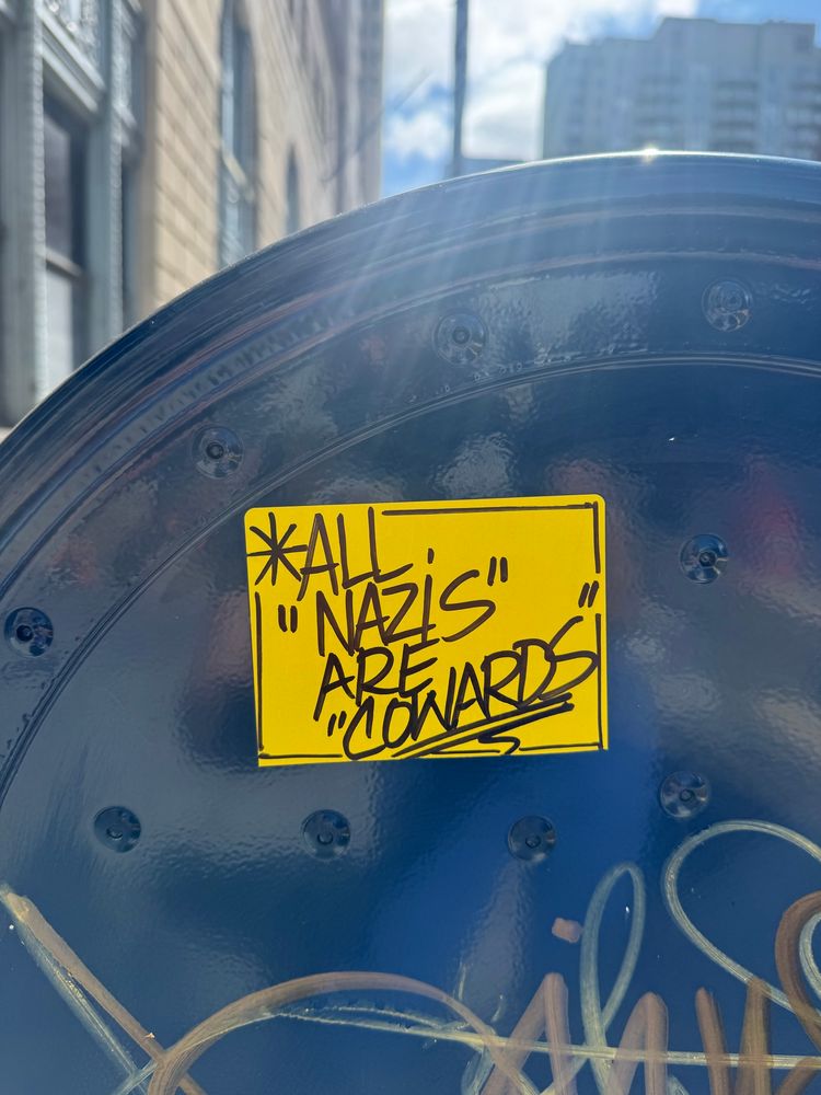 bright yellow ALL NAZIS ARE COWARDS sticker on a mailbox 