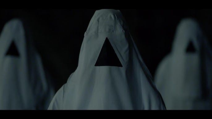 Image from THE VOID of three figures in white hoods with a black triangle over their faces.