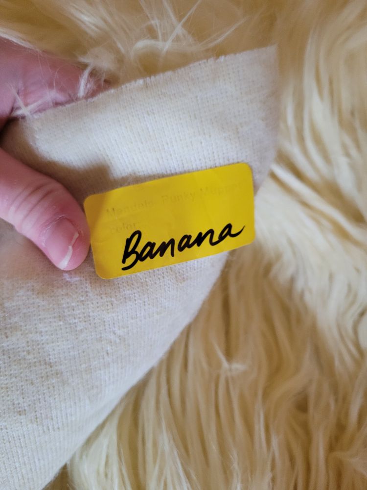 Fur fabric. Light yellow color. Tag that says "banana"