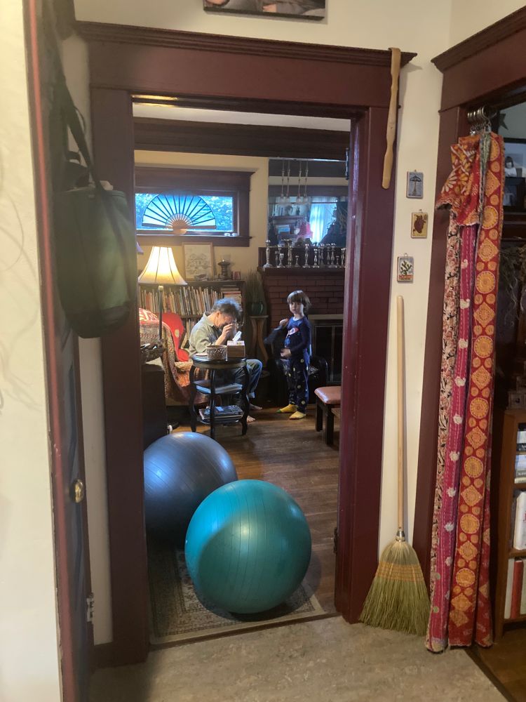 indoor scene featuring a four year old and his grandfather and two large yoga balls.  
