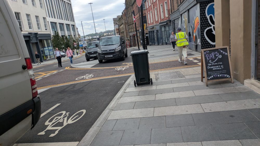 Unfinished bike lane with a white van parked in it